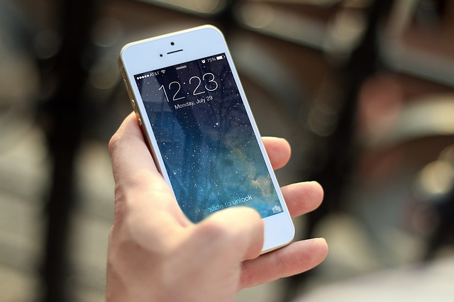 Ruka drží biely iPhone.jpg